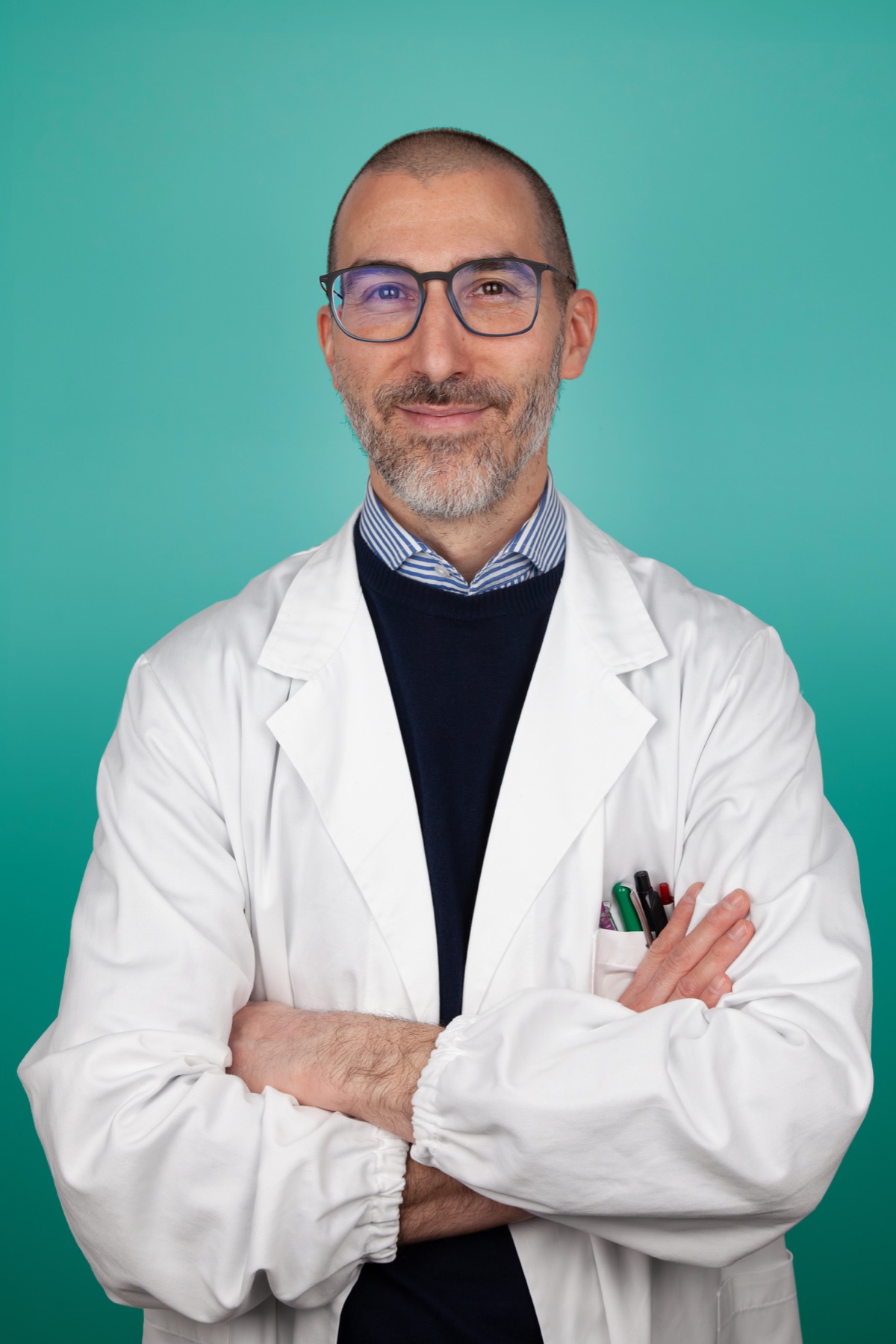 Il Dott. Paolo Bertanzetti in camice bianco, a braccia conserte
